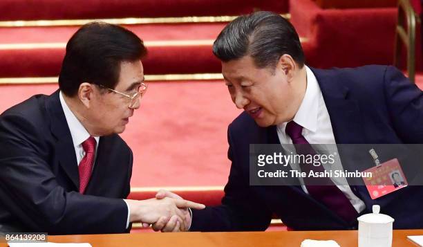 Chinese President Xi Jinping and former president Hu Jintao shake hands during the opening session of the 19th Communist Party Congress held at the...