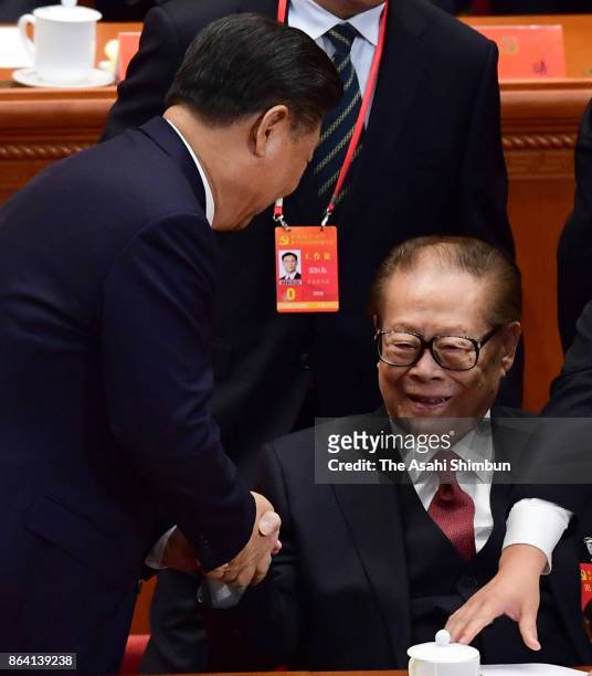 Chinese President Xi Jinping and former president Jiang Zemin shake hands during the opening session of the 19th Communist Party Congress held at the...