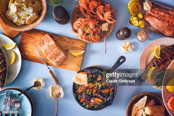 variation of grilled prawns and salmon with fresh lemon - cooking fish stock pictures, royalty-free photos & images