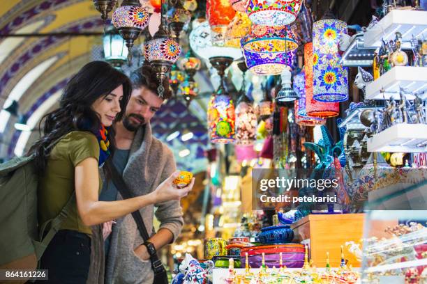 jonge toeristische paar winkelen in de grand bazaar, istanbul, turkije - bazaar stockfoto's en -beelden