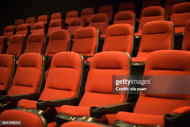 rows of empty red cinema seats - silla vacía fotografías e imágenes de stock