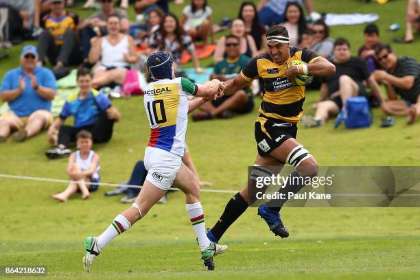 Richard Arnold of the Spirit fends off a tackle by Bryce Hegarty of the Rays during the round eight NRC match between Perth and the Sydney Rays at...