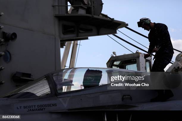 Crew member tends to an F/A-18 E/F Super Hornet on the deck of the U.S. Aircraft carrier Ronald Reagan on October 21, 2017 in Busan, South Korea. The...