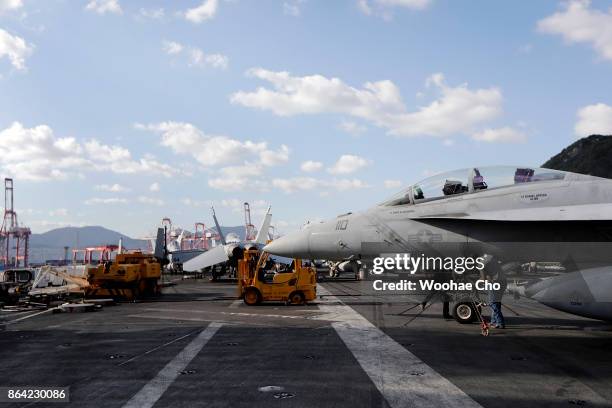 Crew members tend to an F/A-18 E/F Super Hornet on the deck of the U.S. Aircraft carrier Ronald Reagan on October 21, 2017 in Busan, South Korea. The...