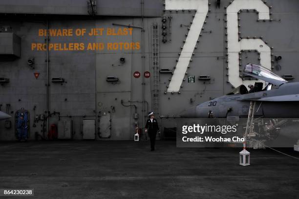 Crew members tend to an F/A-18 E/F Super Hornet on the deck of the U.S. Aircraft carrier Ronald Reagan on October 21, 2017 in Busan, South Korea. The...