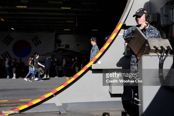 Crew members of US aircraft carrier Ronald Reagan undergo security checks in a hangar bay before disembarking at Busan Naval base on October 21, 2017...