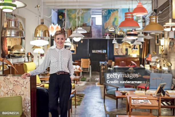 portret van een vrouwelijke ondernemer permanent in haar meubelwinkel - antiek stockfoto's en -beelden