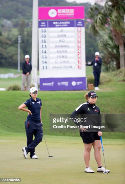 Ariya Jutanugarn of Thailand and Jeong Eun Lee of South Korea stand in front of a scoreboard on the 17th green during day three of the Swinging...