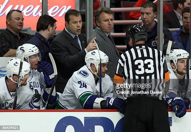 Head coach Alain Vigneault of the Vancouver Canucks talks with referee Kevin Pollock against the Chicago Blackhawks during Game Three of the Western...