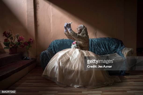 Bride Katty Malang Mikunug, takes a photo of herself in her wedding dress on October 21, 2017 in Saguiaran in Lanao del Sur, southern Philippines....