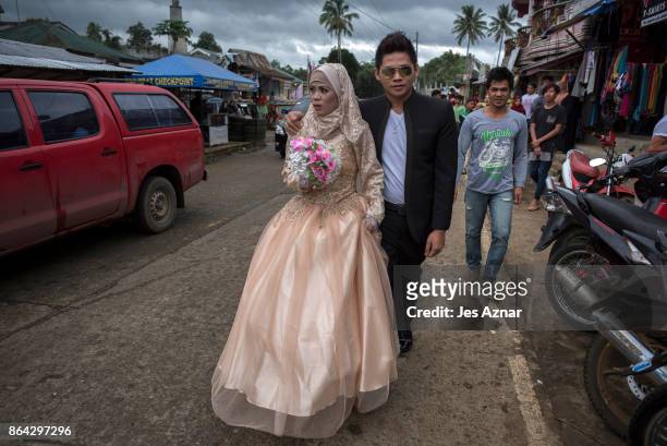 Bride Katty Malang Mikunug , and Paulo Mamayo Ambor walks on a street to be wed on October 21, 2017 in Saguiaran in Lanao del Sur, southern...