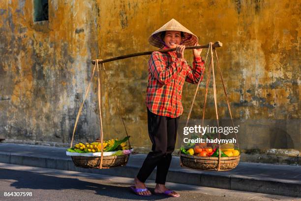 mujer vietnamita vendiendo frutas tropicales, casco antiguo de hoi un city, vietnam - hanoi fotografías e imágenes de stock