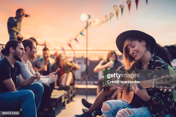 friends drinking and partying on the rooftop - musician stock pictures, royalty-free photos & images