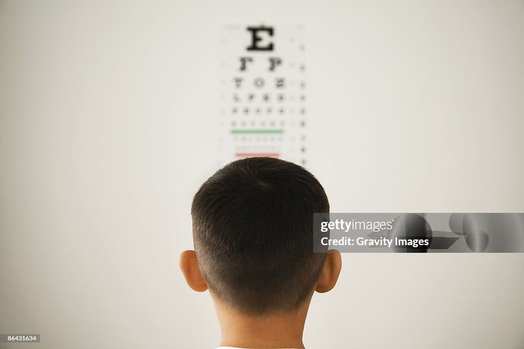 Young boy looking at wall eye chart