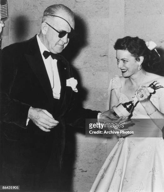 American actress Maureen O'Hara presents film director John Ford with a costumers' award for directorial achievement, circa 1955.
