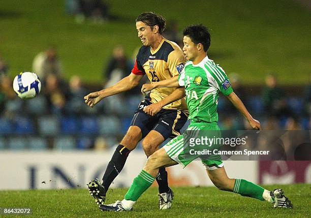 Adam Griffiths of the Jets contests the ball with Zhu Yifan of Guoan during the AFC Champions League Group match between the Newcastle Jets and the...