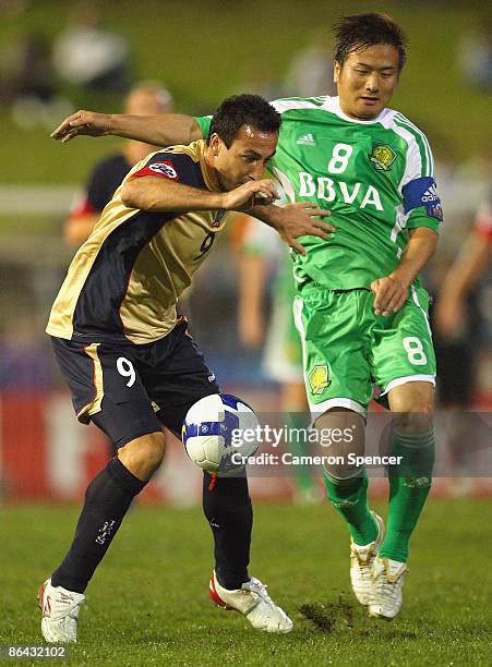 Sasho Petrovski of the Jets contests the ball with Yang Pu of Guoan during the AFC Champions League Group match between the Newcastle Jets and the...