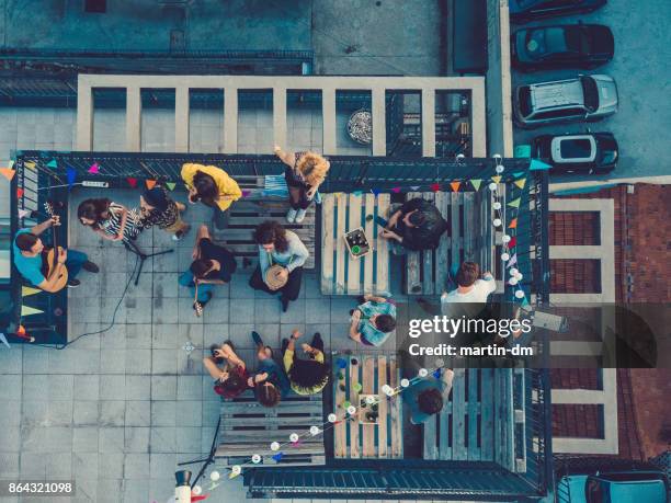 amigos escuchando una banda de música en la azotea - fraternity band fotografías e imágenes de stock