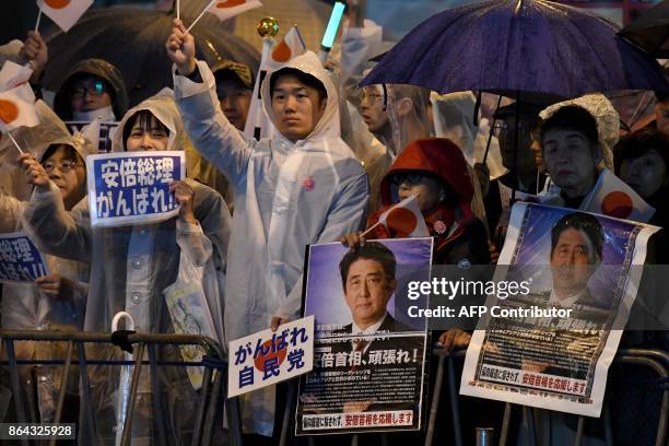 Supporters of the ruling Liberal Democratic Party display posters while waiting for Japan's Prime Minister Shinzo Abe to arrive for his last stumping...