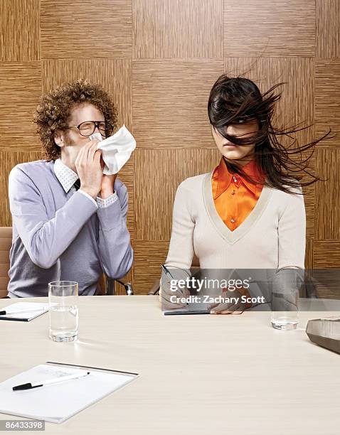 man sneezing on woman in office environment - social grace stock pictures, royalty-free photos & images