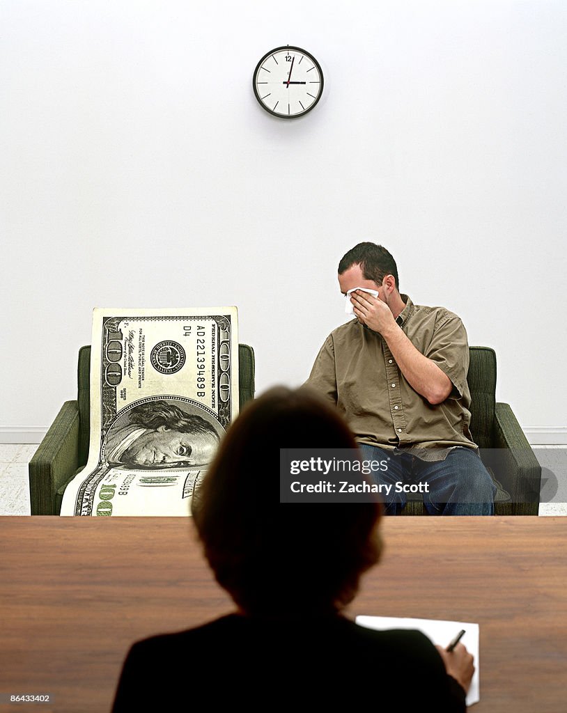 Man and Giant 100 dollar bill see therapist