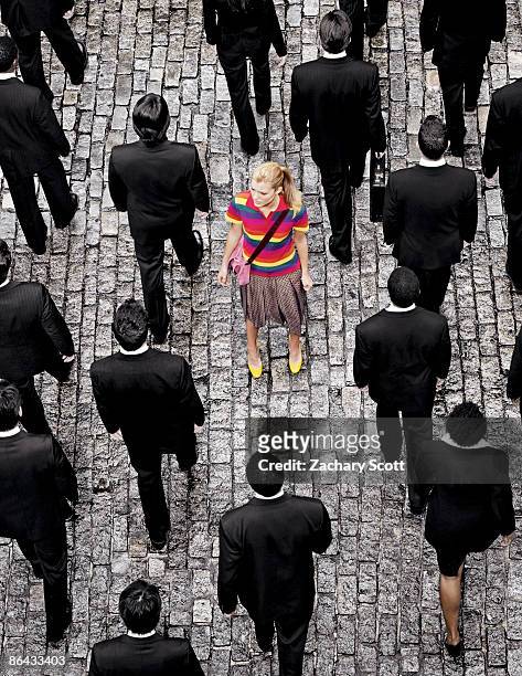 aerial view of a woman "standing out" on a street - aus der reihe tanzen stock-fotos und bilder