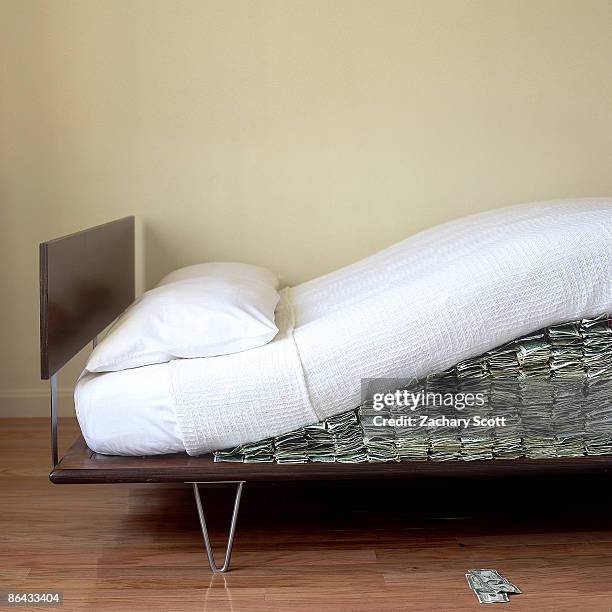 money hidden under modern bed mattress - materasso foto e immagini stock