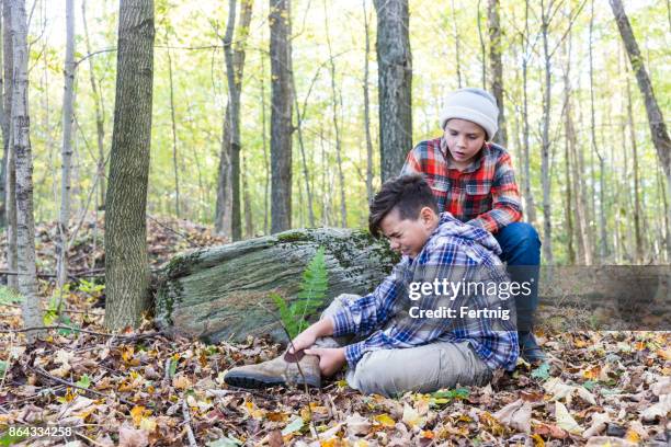 brother helping his injured brother in the forest - twisted ankle stock pictures, royalty-free photos & images