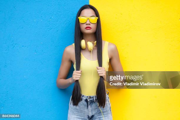 serious woman in yellow vest and sunglasses with long hair - girl headphones imagens e fotografias de stock