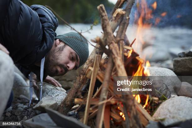 junges paar ein lagerfeuer machen. bergige landschaft - maka stock-fotos und bilder