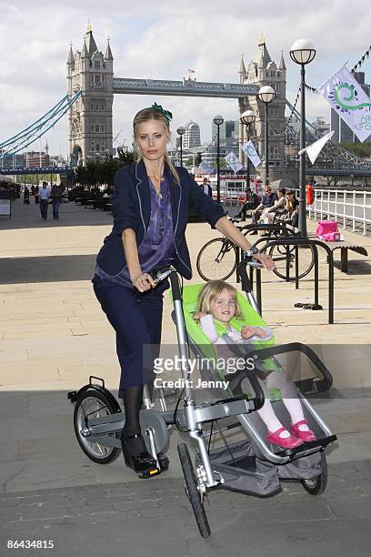 Laura Bailey with a child model give the Taga pram-bike a test drive outside the Design Museum on May 6, 2009 in London, England.