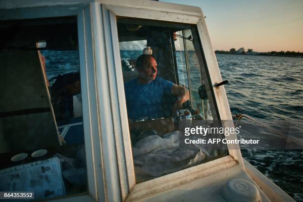 Stefan Toporau, the owner of a small local fishing company who uses dolphin friendly fishing nets, sails on his boat on September 1, 2017 on the...