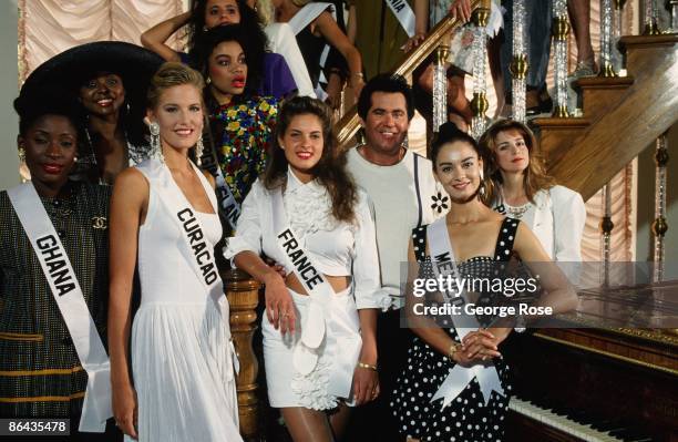 Singer and actor Wayne Newton poses with several Miss Universe contestants in his living room during a 1991 Las Vegas, Nevada, tour of his suburban...