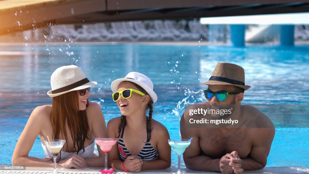 スイミング プールで coktail を飲んで幸せな家族