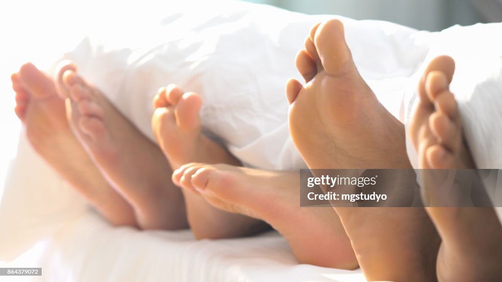 Family foot in Bed have Fun Sunday Morning