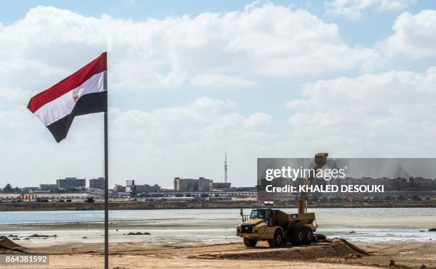 Picture taken on October 21 shows an Egyptian flag flying near a construction digger at the site of the New Alamein City, situated about 100...