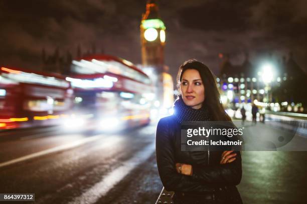 joven esperando un taxi en londres en la noche - clave baja fotografías e imágenes de stock