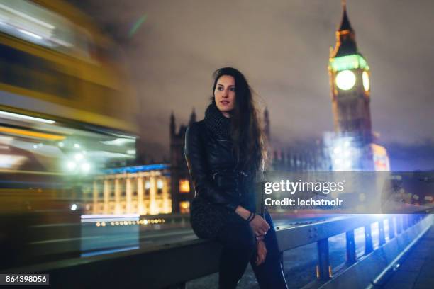 young woman waiting for a taxi in london at night - low key imagens e fotografias de stock