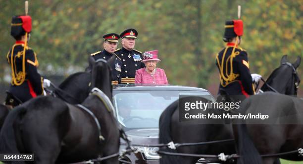 Queen Elizabeth II, accompanied by Major General Matthew Sykes and Lieutenant General Sir Andrew Gregory , stands in her State Review Range Rover to...