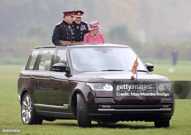 Queen Elizabeth II, accompanied by Major General Matthew Sykes and Lieutenant General Sir Andrew Gregory , stands in her State Review Range Rover to...