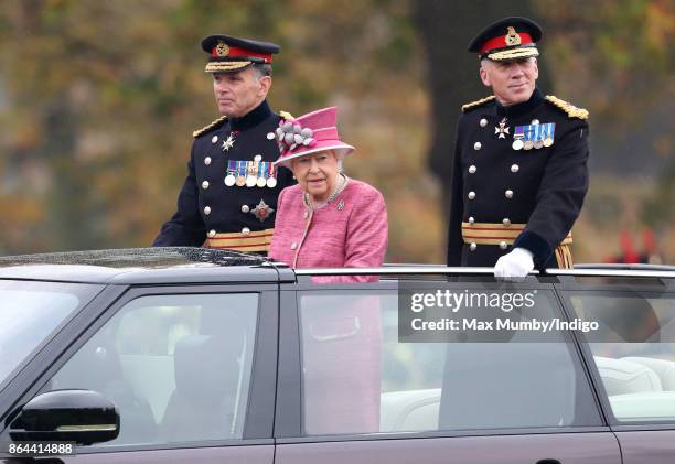 Queen Elizabeth II, accompanied by Major General Matthew Sykes and Lieutenant General Sir Andrew Gregory , stands in her State Review Range Rover to...