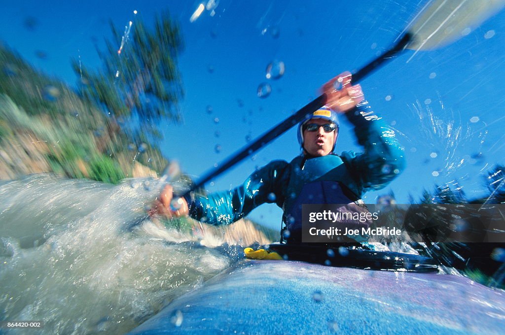 Whitewater kayaking, close-up, low angle view (blurred motion)