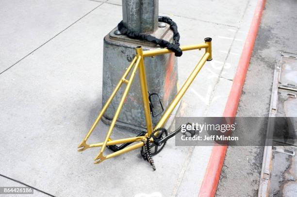 bicycle frame chained to pole - fagotto foto e immagini stock