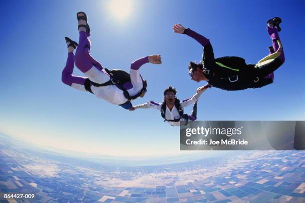 skydivers linked in free fall formation, low angle view [1995] - wide angle sky stock pictures, royalty-free photos & images