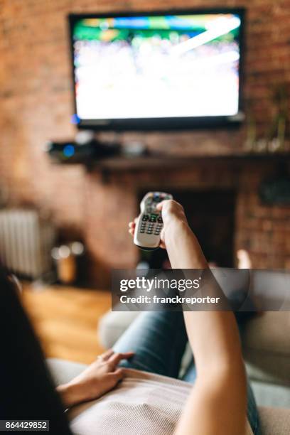 woman looking the tv at home - feet up tv stock pictures, royalty-free photos & images