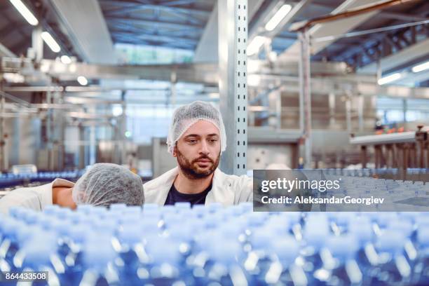 twee mannelijke controllers doen herziening in de bottelinstallatie - bottle factory stockfoto's en -beelden