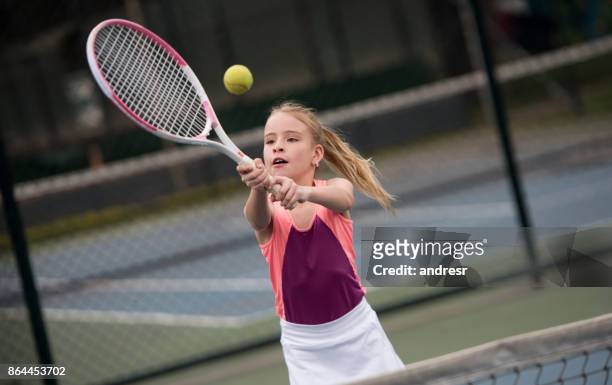 mädchen mit dem tennisspielen und kollision mit einem ball mit dem schläger - tennis 2017 stock-fotos und bilder
