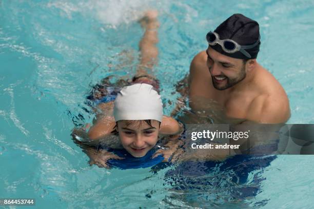 swimming instructor teaching a boy in the pool - swimming coach stock pictures, royalty-free photos & images