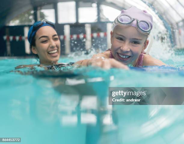 girl taking swimming lessons with a teacher - kids clubhouse stock pictures, royalty-free photos & images