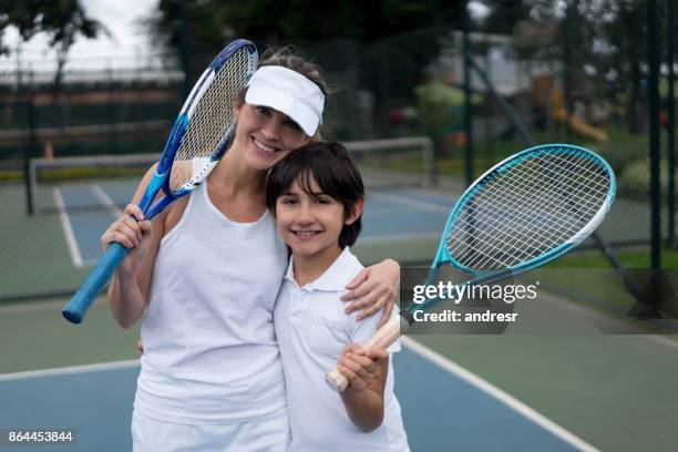 happy mother and son playing tennis outdoors - kids clubhouse stock pictures, royalty-free photos & images